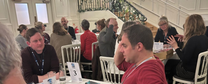 Large conference room filled with people talking to each other