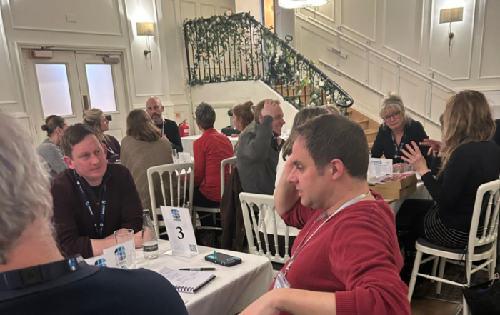Large conference room filled with people talking to each other